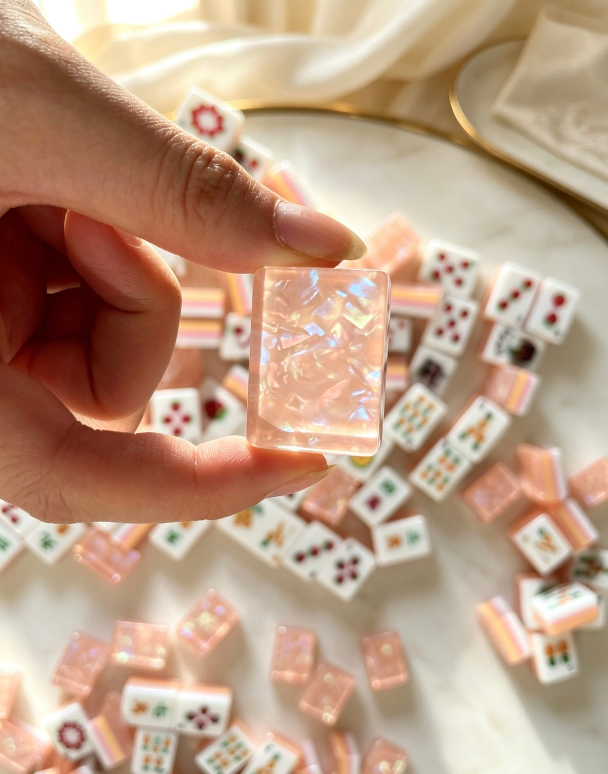 MAHORA Fruity Sparkle: Hand holding a sparkling peach tile back