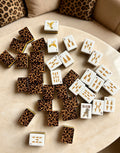 MAHORA Leopard Print: White tile faces and leopard-pattern backs scattered on a cream table
